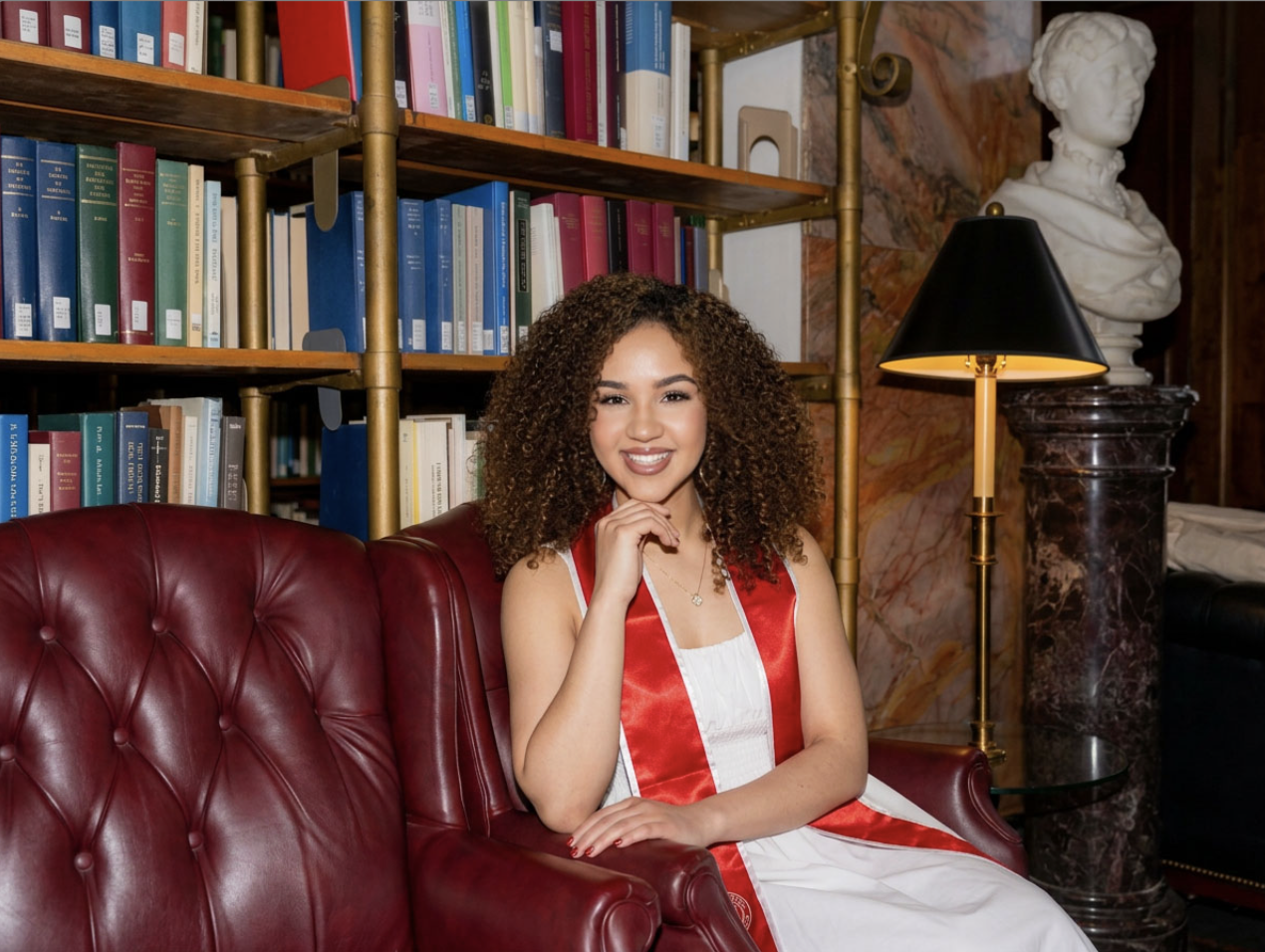Mary Bellakbira sitting in a library chair wearing a red sash